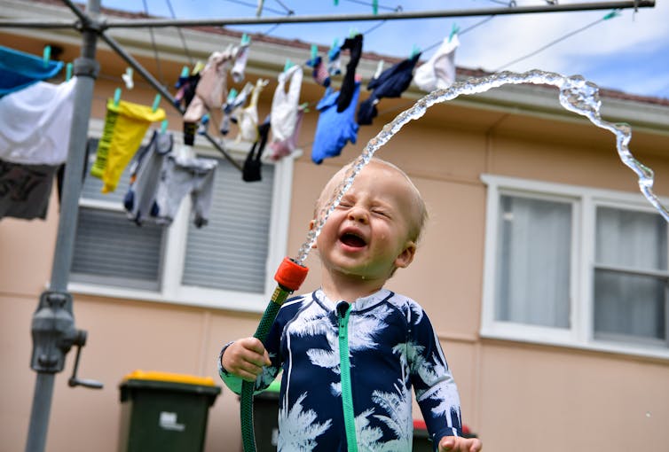 delighted boy holds hose