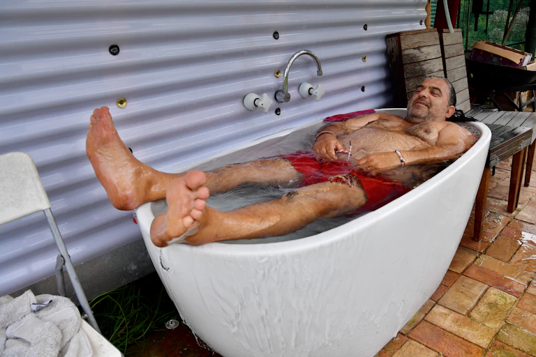 man reclines in outdoor bath
