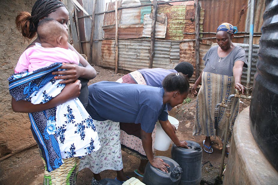 Womrn queue to fetch water in buckets.