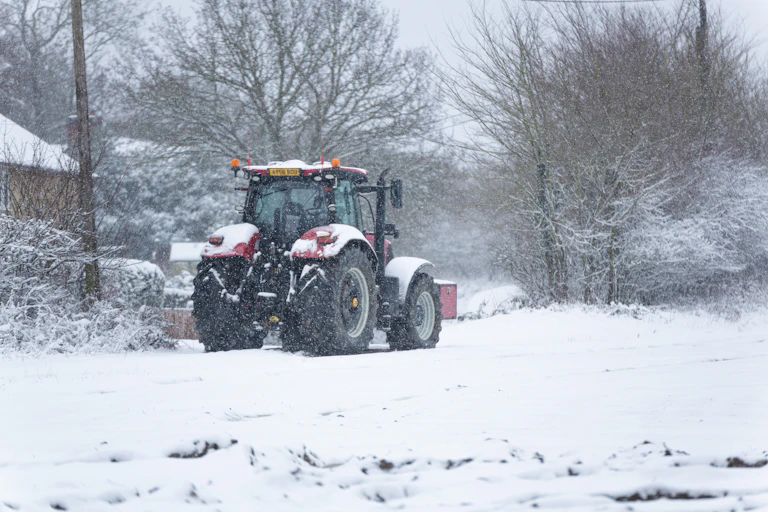A tractor on a snowy field in Suffolk.