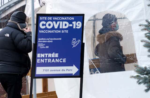 Des gens entrent dans une clinique de vaccination