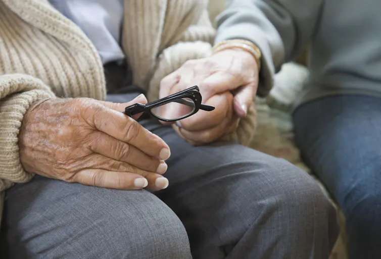 Senior citizens sitting, holdin hands