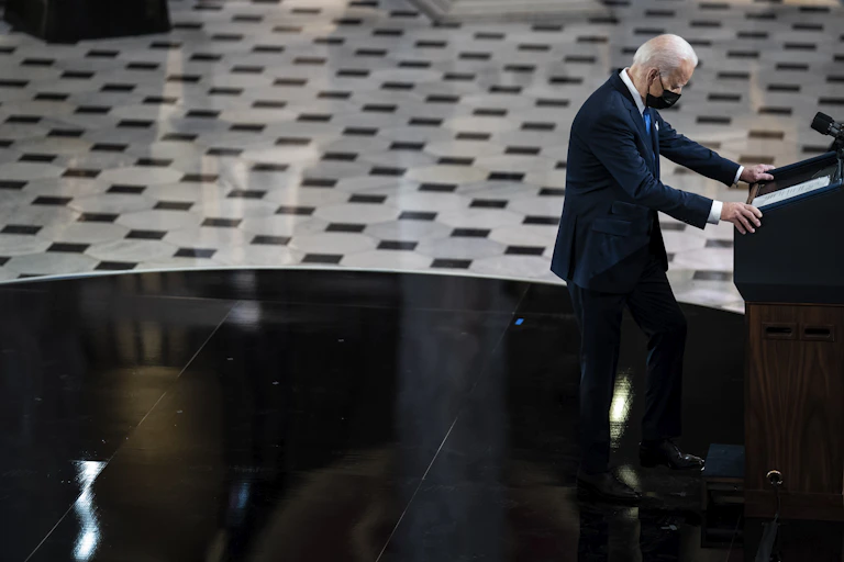 President Joe Biden with his hands on a lectern preparing to deliver an address.