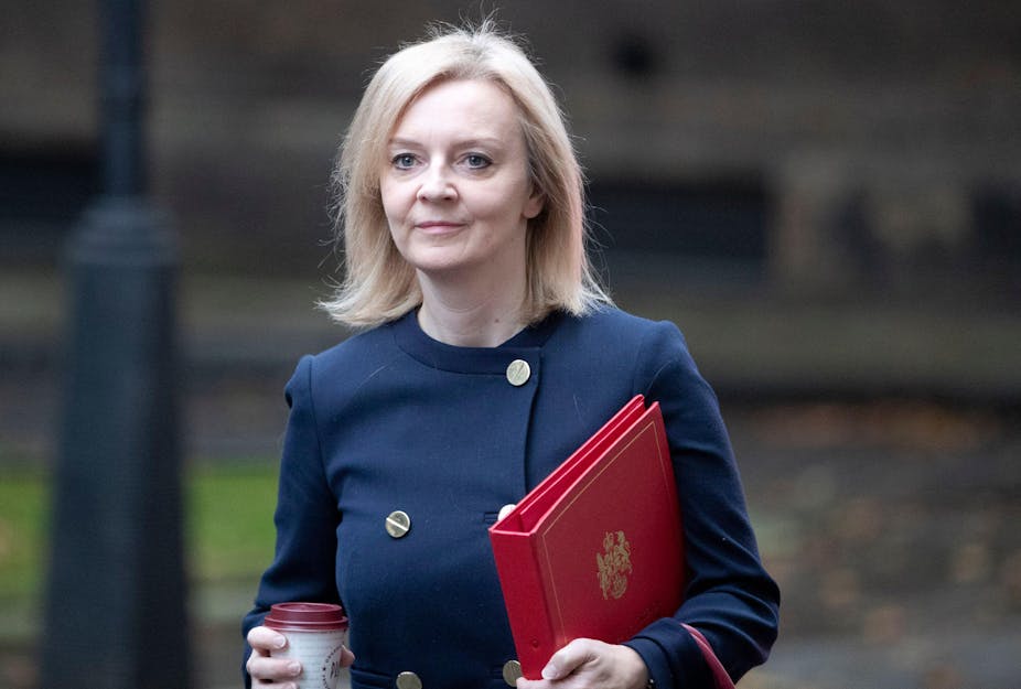 Foreign secretary Liz Truss carries a red minister's folder and wearing a navy jacket