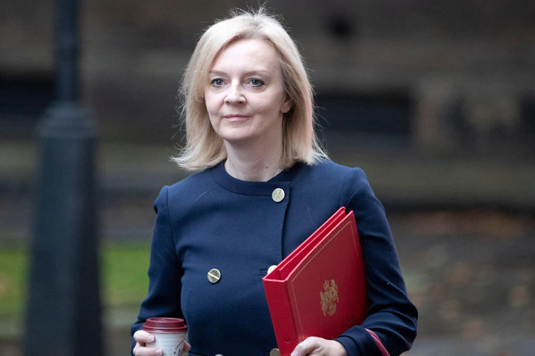 Foreign secretary Liz Truss carries a red minister's folder and wearing a navy jacket