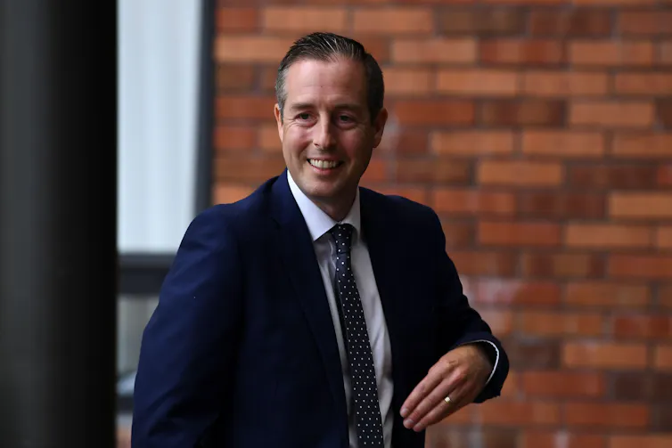 First Minister Paul Givan wearing a suit and smiling