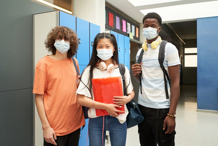 Students standing in a hallway in face masks.