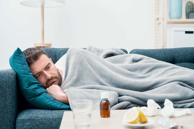 Man lying on couch sick