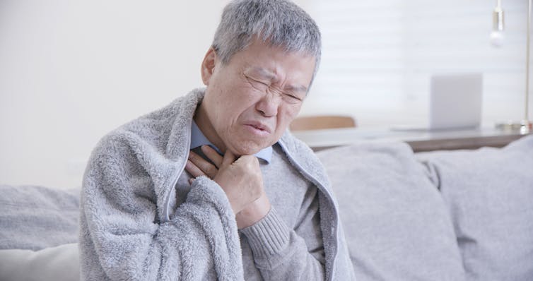 Person sick at home holding chest