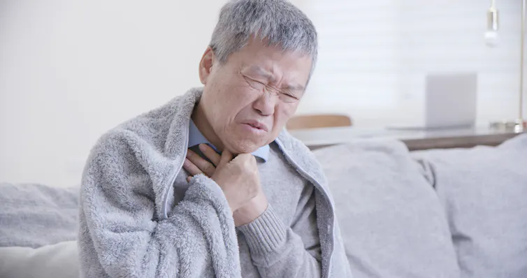 Person sick at home holding chest
