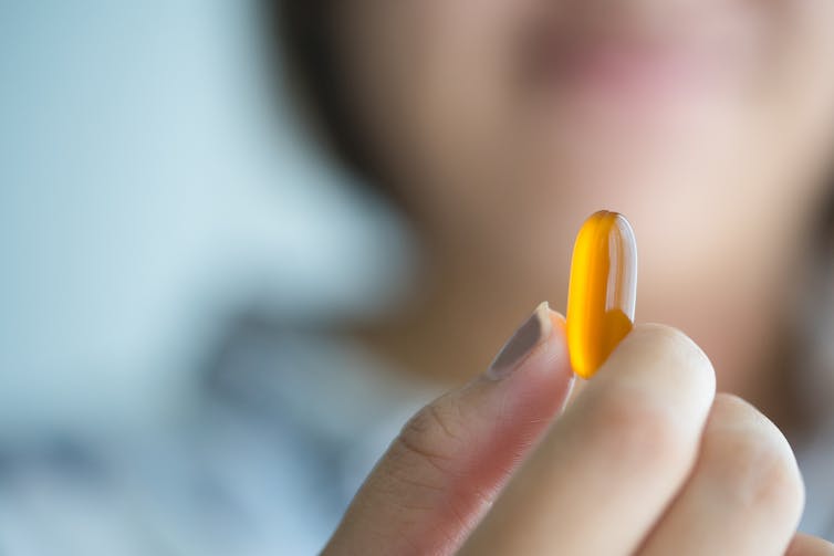 Woman holding up dietary supplement