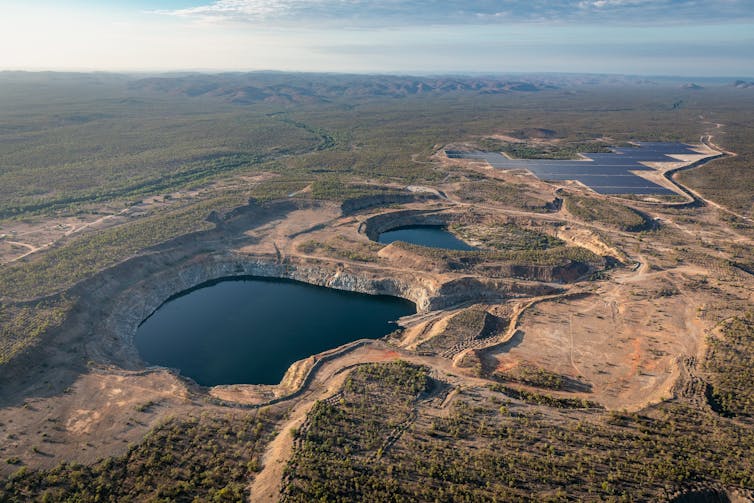 Aerial view of a pumped hydro project's two reservoirs and solar array on a dry landscape