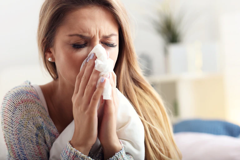 A woman blowing her nose