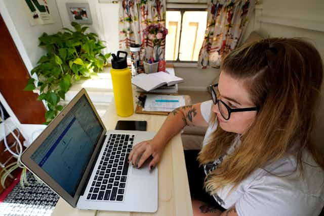 A young woman uses a laptop computer