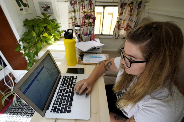 A young woman uses a laptop computer