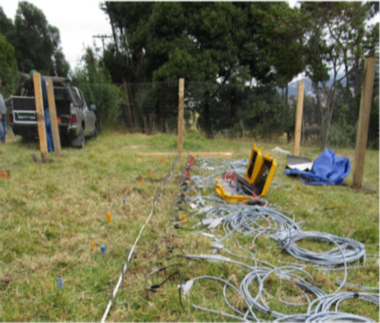 Local de enterro na Colômbia mostrando equipamento elétrico sendo usado para detectar restos mortais