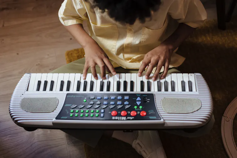A child's fingers are seen on a keyboard.