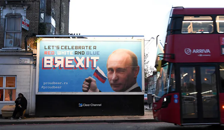 Une affiche montre Vladimir Poutine avec un drapeau russe. On peut lire « Célébrons le Brexit rouge, blanc, bleu »