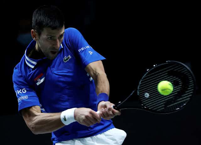 Close-up action shot of Novak Djokovic hitting a tennis ball during the Davis Cup in Madrid