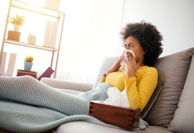 A woman blowing her nose