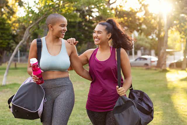 Deux femmes en tenue d'exercice dans un parc.