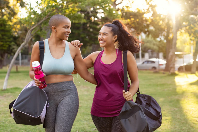 Deux femmes en tenue d'exercice dans un parc.