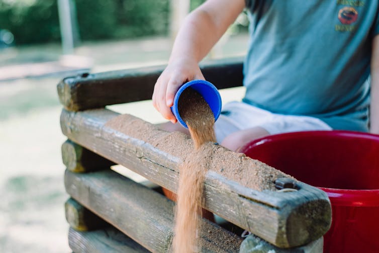 Child pouring out sand.