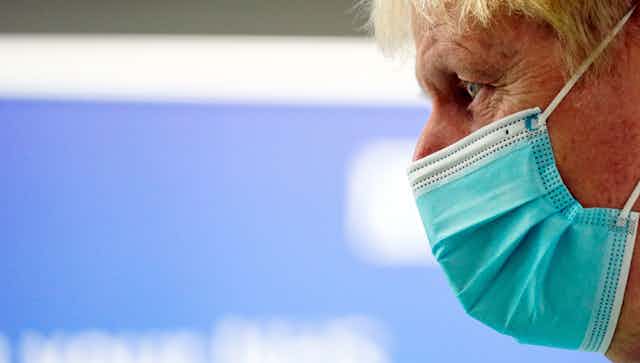 Boris Johnson in profile wearing a covid mask