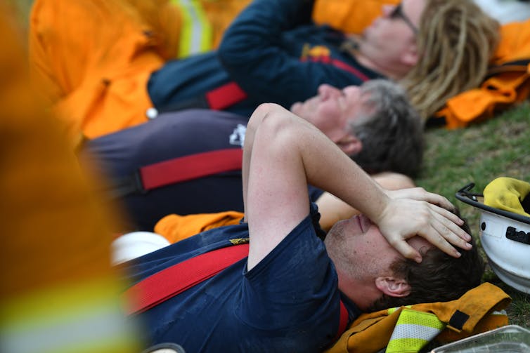 Firefighter holds head while lying down