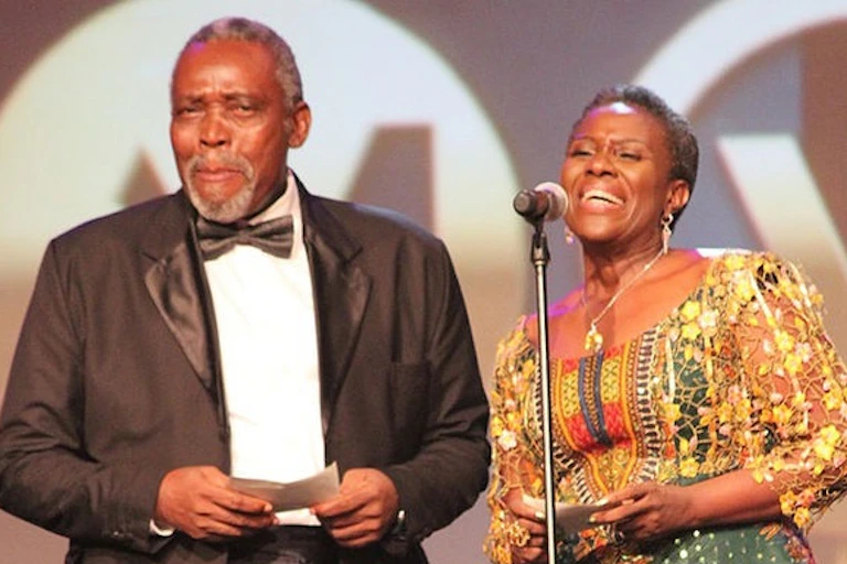Man and woman on stage with a microphone receiving an award.