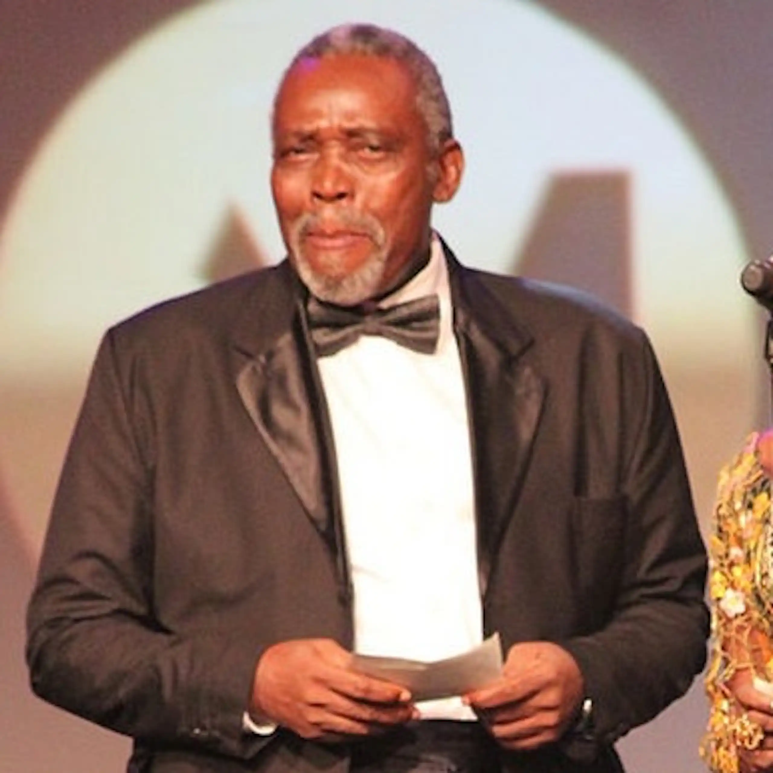 Man and woman on stage with a microphone receiving an award.