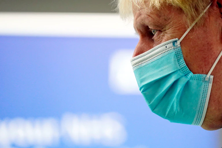 Boris Johnson de perfil con una mascarilla