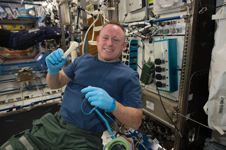 An astronaut holds a plastic ratchet
