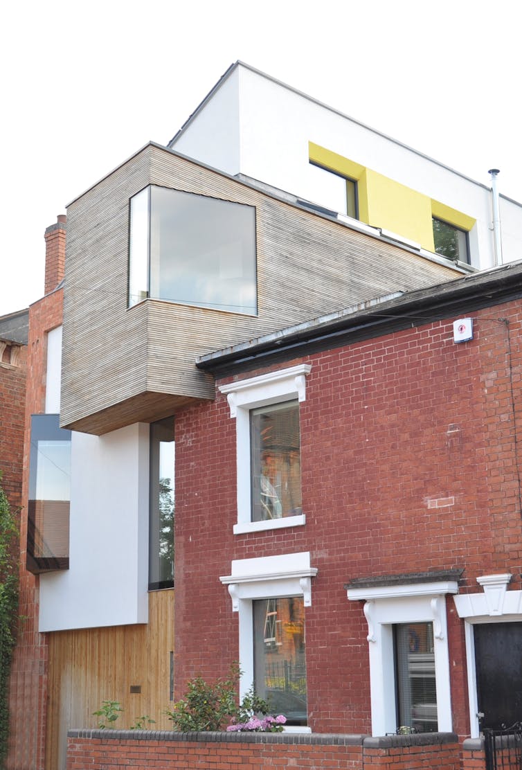 A modernist extension on a red brick traditional house.