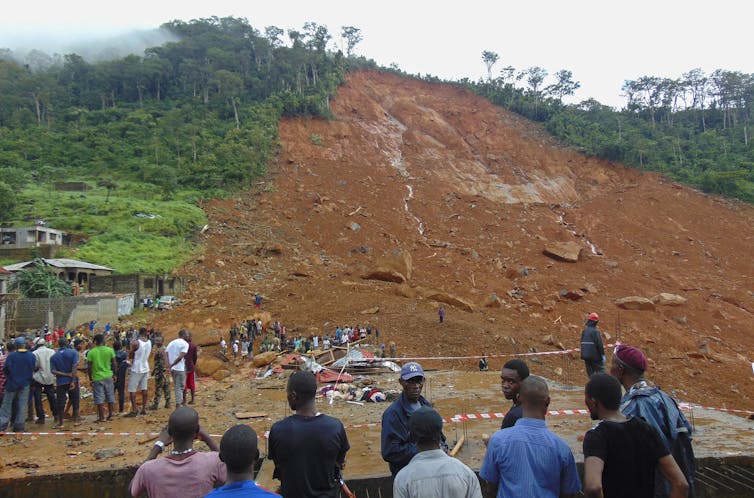 Hillside covered in mud, people watching