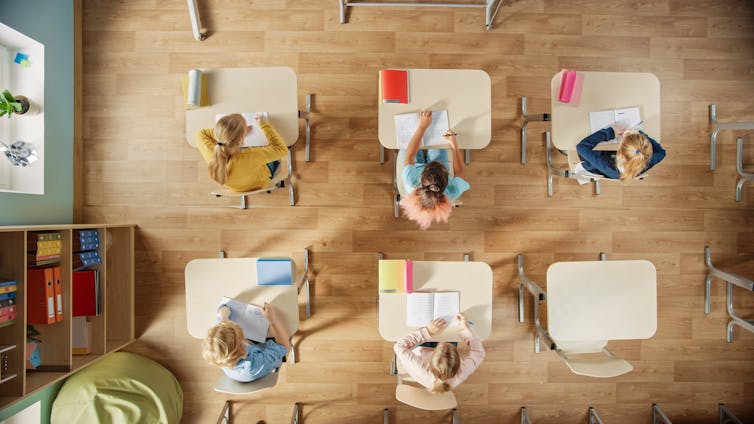 Un aula de alumnos en sus escritorios, visto desde arriba.
