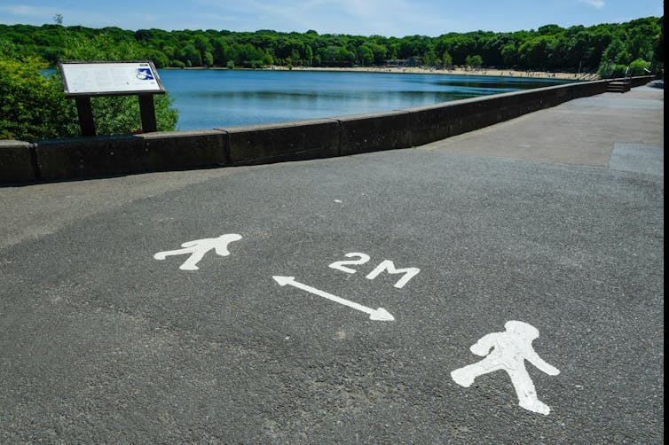 A pandemic marking on a pavement showing people they must stay 2 metres apart.