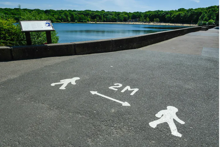 A pandemic marking on a pavement showing people they must stay 2 metres apart.