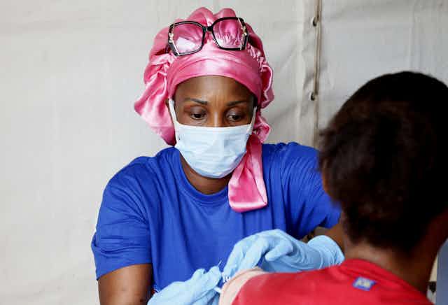 A medical worker vaccinating someone in Cote d'Ivoire