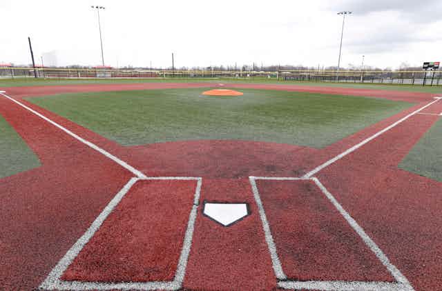 Image shows empty baseball field from a view behind home plate