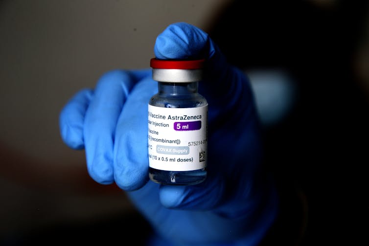 A health worker holding a vaccine vial