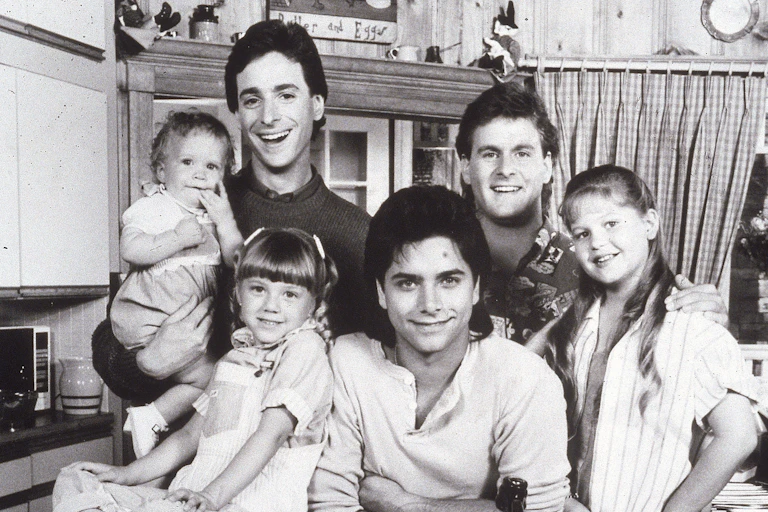 Three men and three girls pose in front of a sink.
