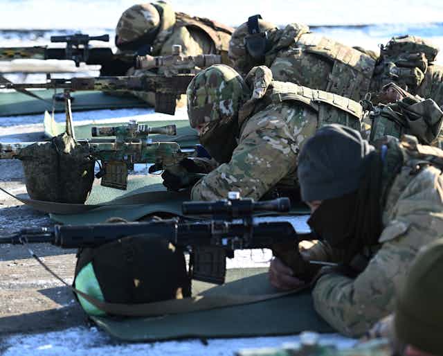 Soldiers aiming rifles