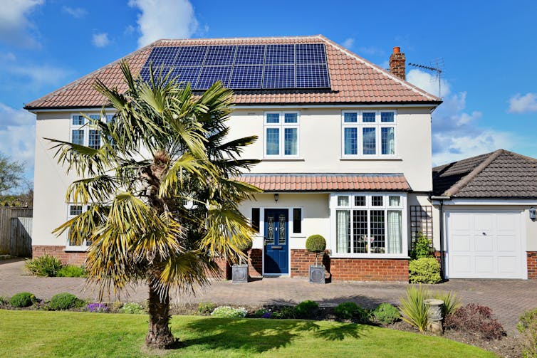 Large detached house with solar panels on roof.