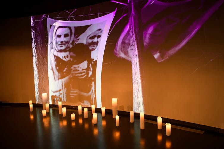 An image of a starving Ukrainian woman is projected on to a wall behind candles lit in remembrance of the millions of Ukrainians who died in the Holodomor famine.