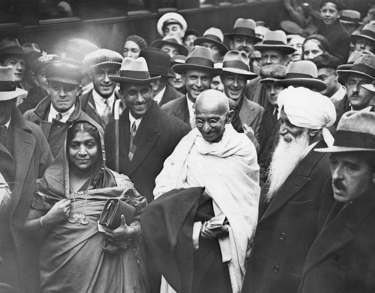 Gandhi walks in a crowd.