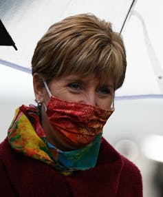 Headshot of a person with short hair wearing a face mask.