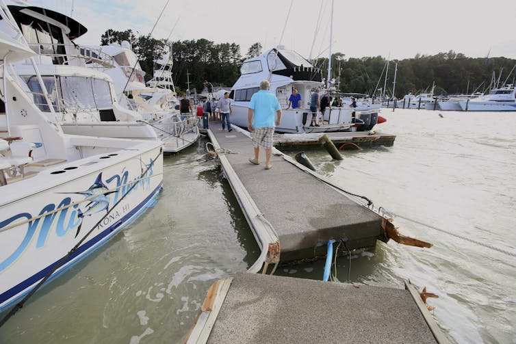 broken dock with man and boats
