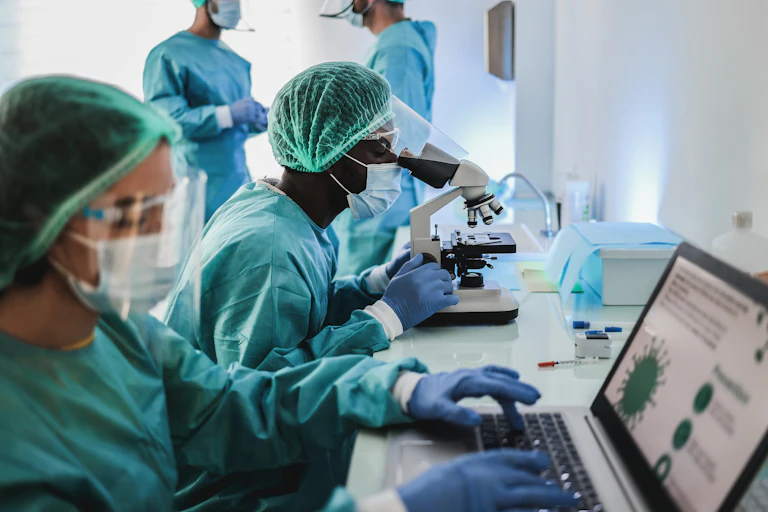 scientists in hazmat suit working with microscope