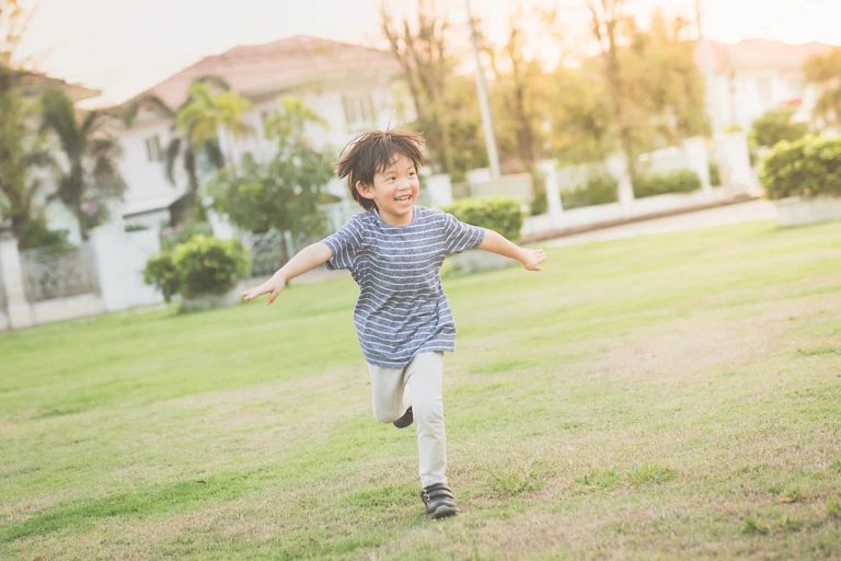 Small boy running outside